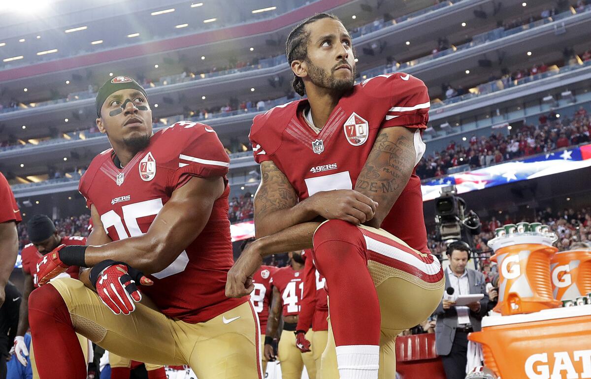 San Francisco 49ers teammates Eric Reid and Colin Kaepernick kneel during the national anthem.