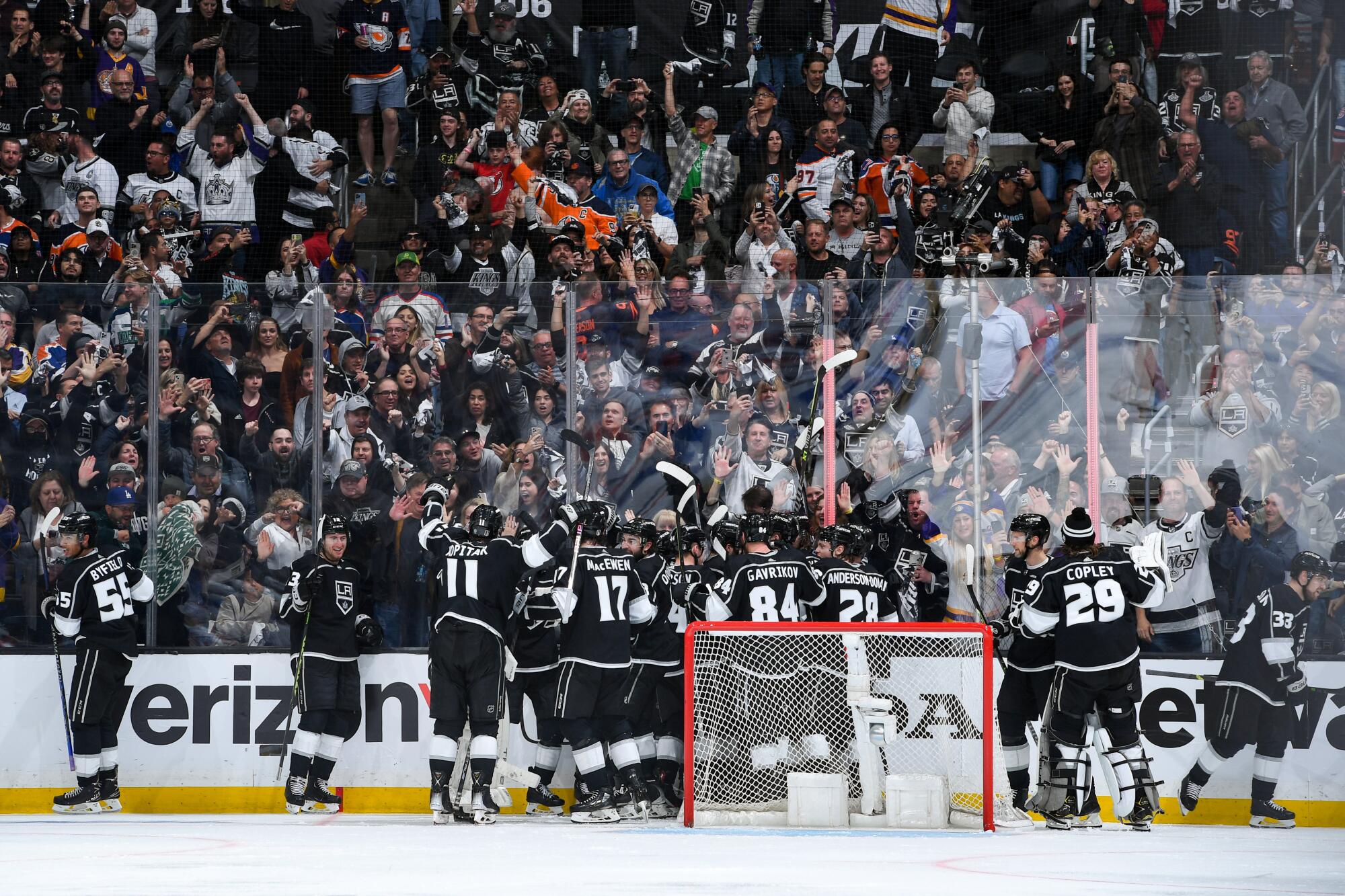 Kings players celebrate after Trevor Moore scores in overtime to cap a 3-2 win over the Edmonton Oilers.