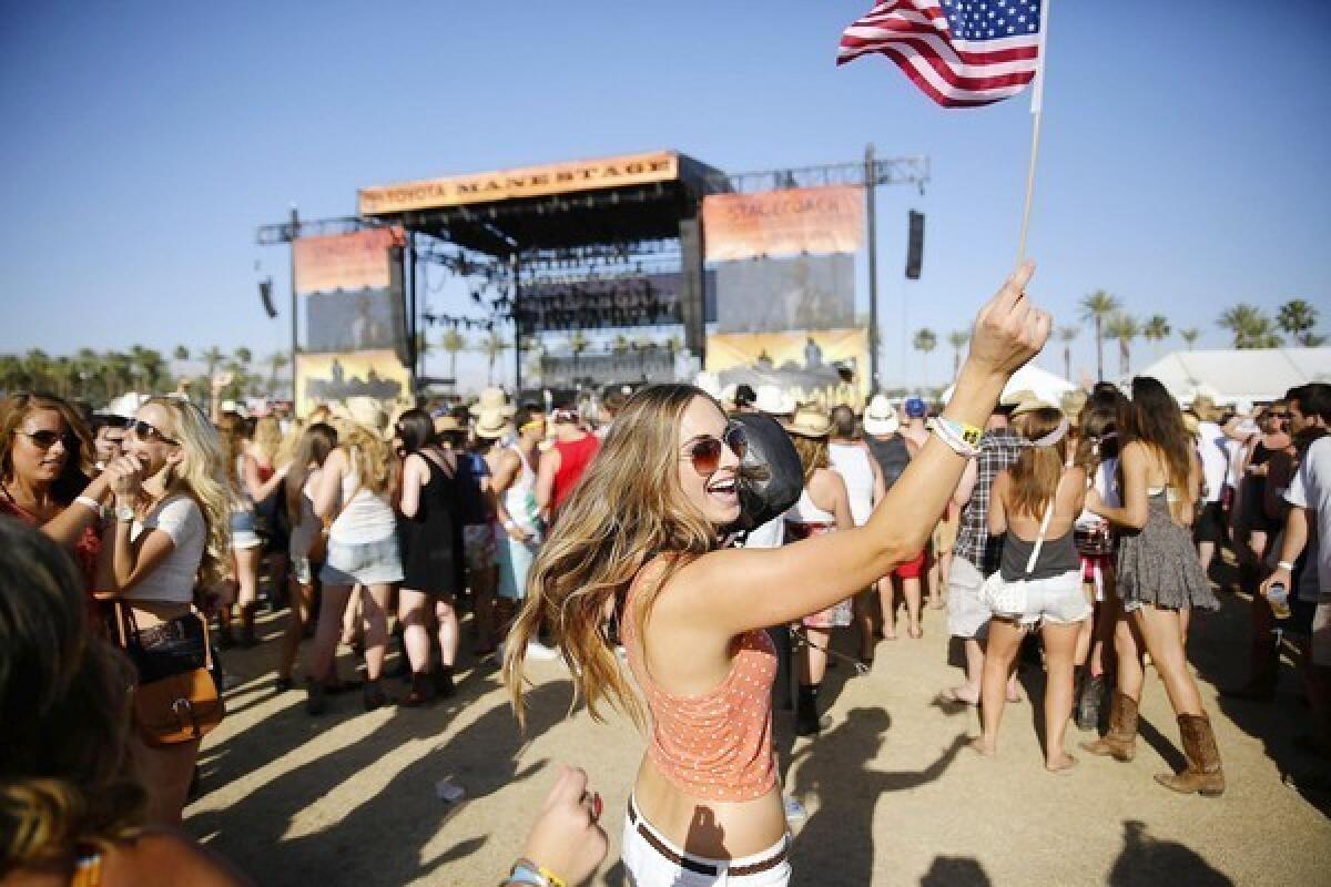 Megan Kirpatrick of San Diego holds an American flag as she dances during day two of the Stagecoach country music festival at the Empire Polo Club in Indio.