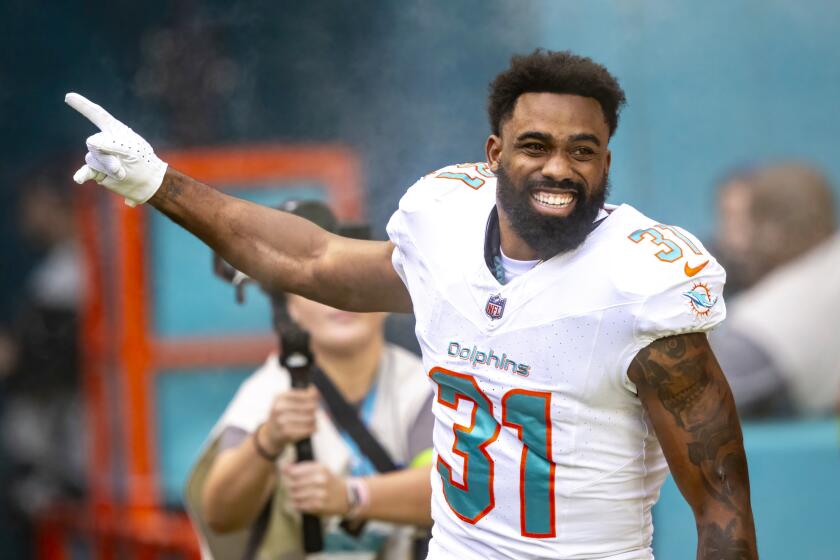 ARCHIVO - El running back de los Dolphins de Miami, Raheem Mostert (31), sonríe y gesticula mientas corre dentro del campo durante la presentación de los jugadores en un partido de la NFL en contra de los Jets de Nueva York, el domingo 17 de diciembre de 2023, en Miami Gardens, Florida. Mostert acordó una extensión de contrato que lo mantendrá en Miami hasta la temporada 2025, anunció su agente Brett Tessler el viernes 29 de marzo de 2024. (AP Foto/Doug Murray, Archivo)