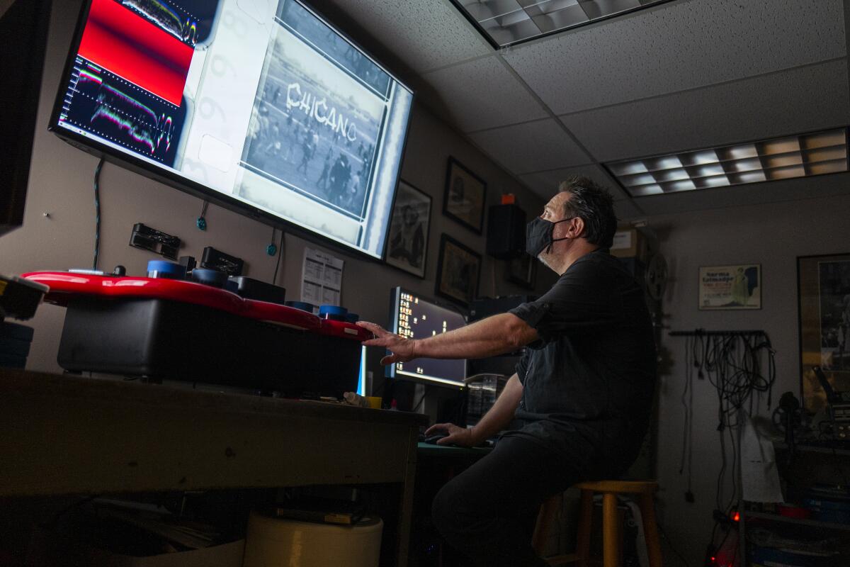 USC archivist Dino Everett looks at an image and tracking bars on a large screen.