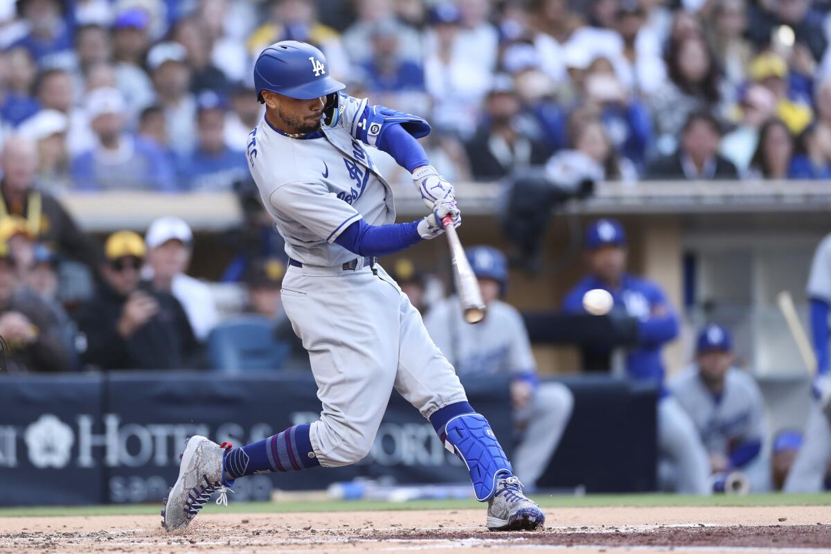 Dodgers center fielder Mookie Betts swings at a pitch during a baseball game against the San Diego Padres on Saturday.