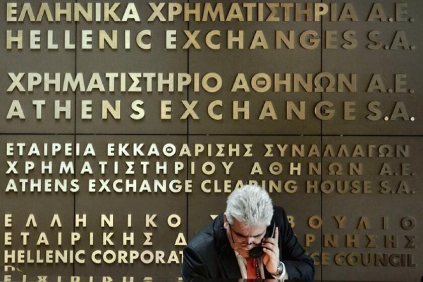 Investors dumped shares of the National Bank of Greece and Eurobank after the institutions confirmed that their merger was on hold. Above, an employee at the Athens stock exchange.