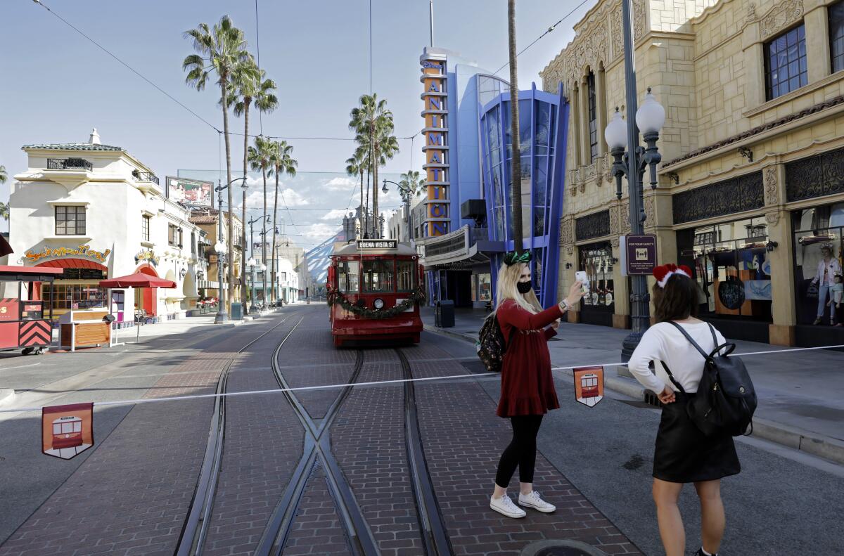 Visitors take pictures in front of a tram at the Disney California Adventure.