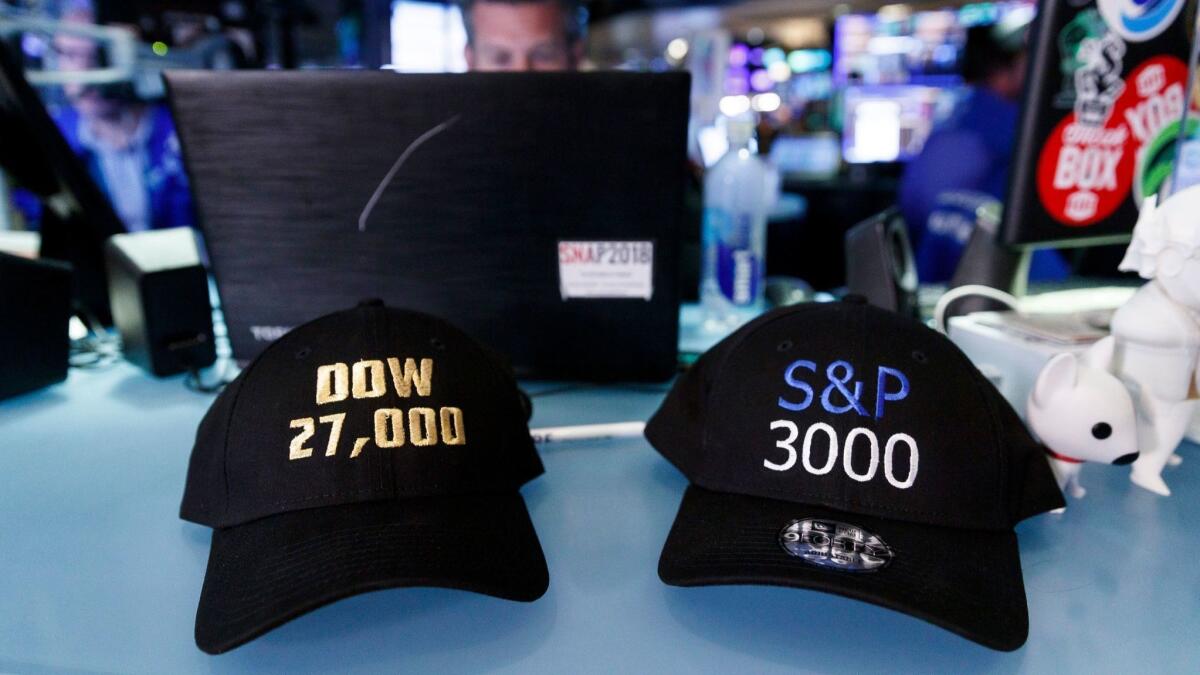 Hats touting milestones for the Dow Jones industrial average and the Standard & Poor's 500 index are displayed on the floor of the New York Stock Exchange.