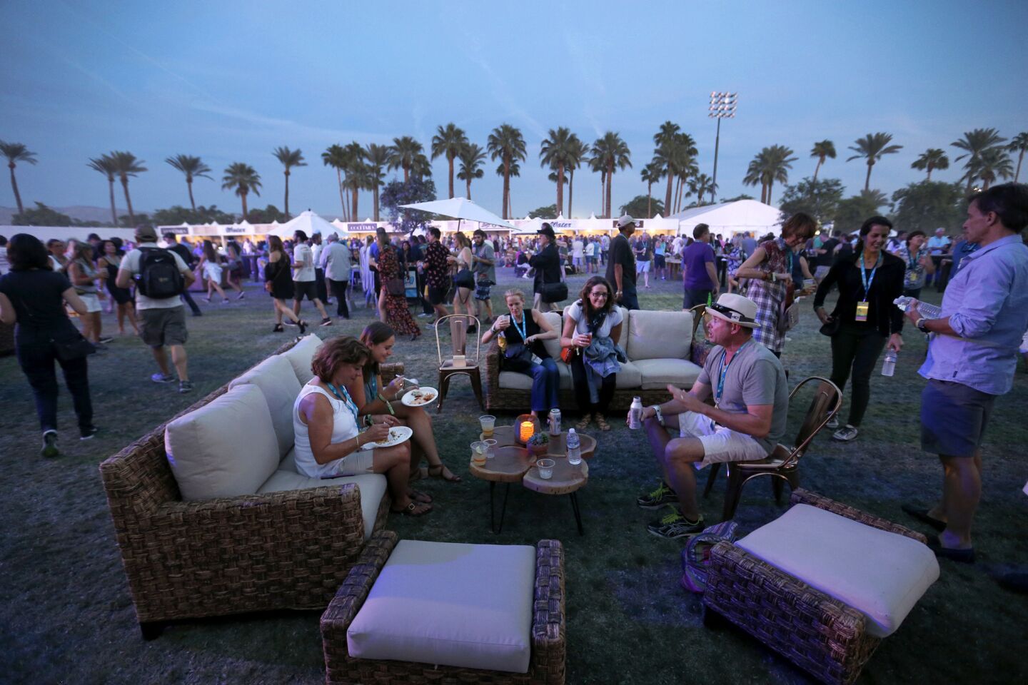 Concertgoers eat, drink and relax at dusk on the first day of the three-day Desert Trip at the Empire Polo Club grounds in Indio.