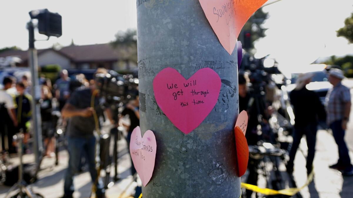 Handwritten notes are displayed on a light post across the street from the Chabad of Poway Synagogue after a shooting in Poway, Calif. on April 27.