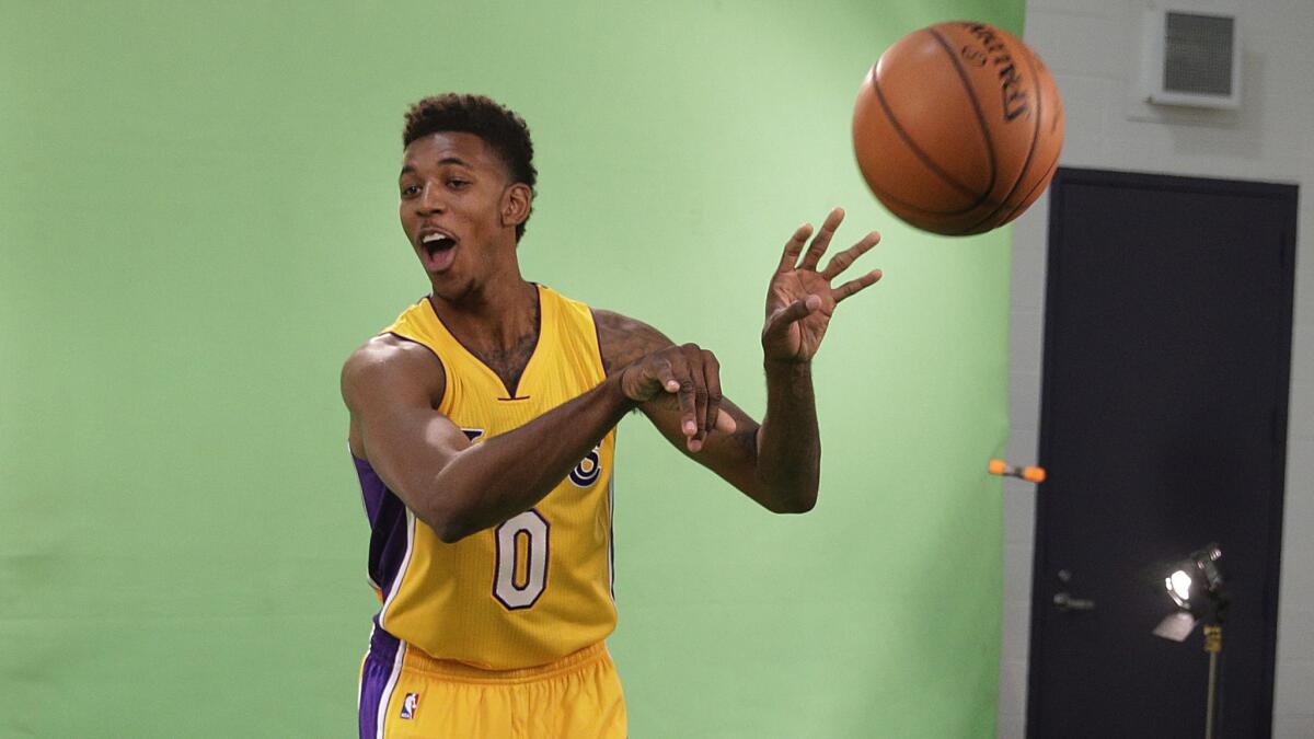 Lakers forward Nick Young tosses a ball while taking part in a video shoot at the team's media day Monday.