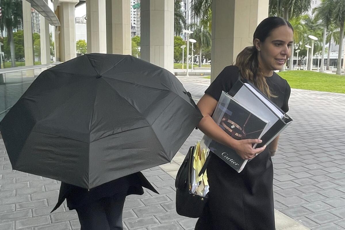 La famosa diseñadora de bolsos Nancy González se esconde bajo un paraguas 