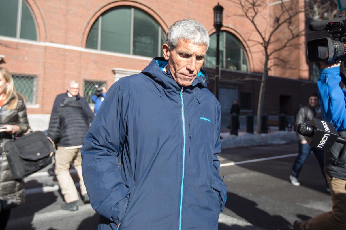 William "Rick" Singer leaves Boston Federal Court after being charged with racketeering conspiracy, money laundering conspiracy, conspiracy to defraud the United States, and obstruction of justice on March 12.