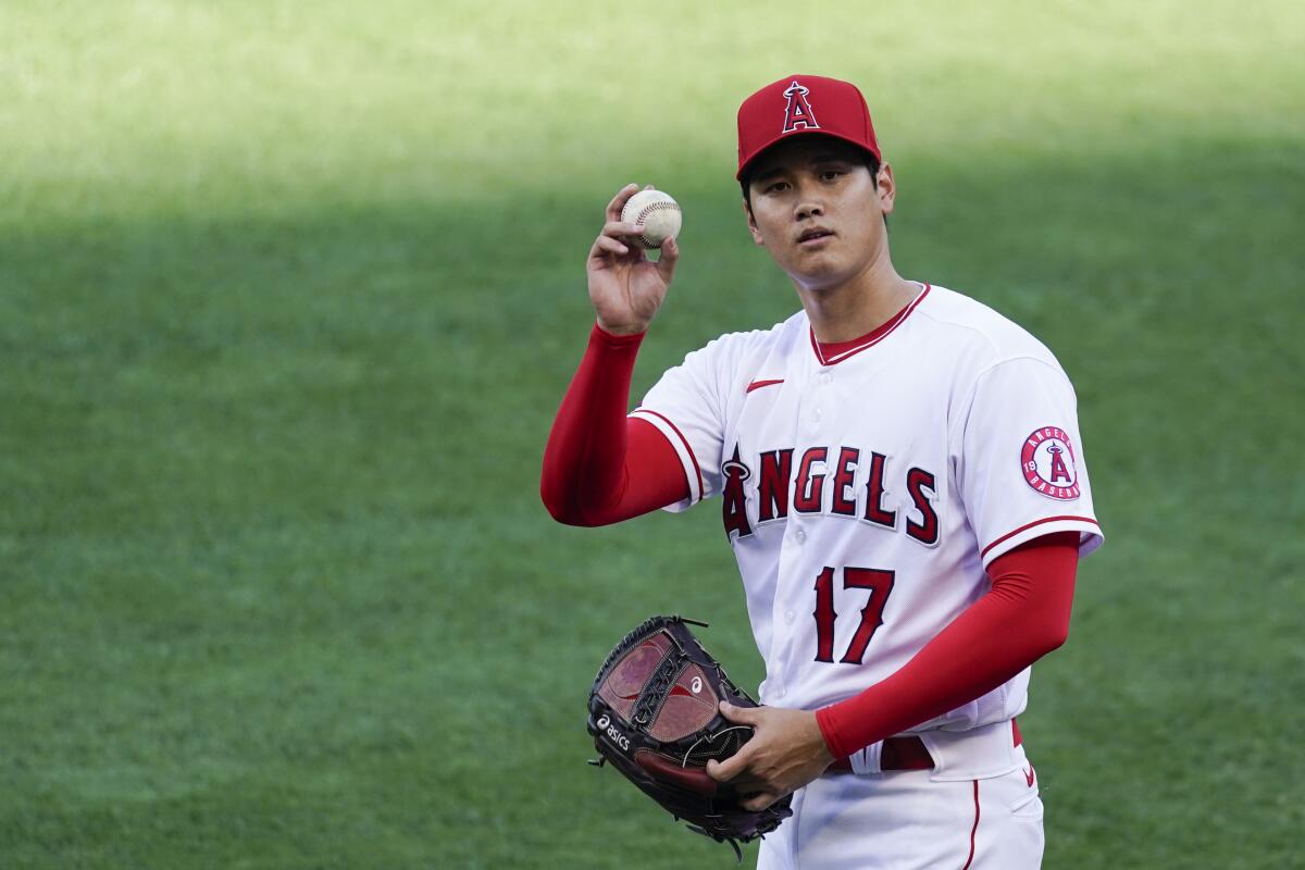 Los Angeles Angels starting pitcher Shohei Ohtani (17) throws a ball to fans as he warms up.