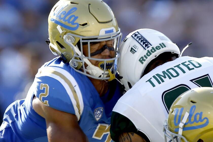 FILE - In this Sept. 9, 2017, file photo, Hawaii wide receiver Kalakaua Timoteo, center, drops the ball and gets leveled by UCLA linebacker Josh Woods, left, and hit from behind by defensive back Mossi Johnson (21), during the second half of an NCAA college football game in Pasadena, Calif. Woods was penalized for targeting and ejected. College footballâs Bowl Subdivision has seen a 73-percent increase in the number of targeting penalties enforced through the first three weeks of the season compared with the same point in 2016.(AP Photo/Alex Gallardo, File)