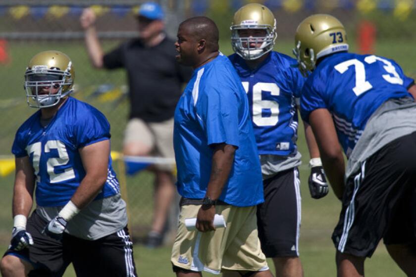 UCLA offensive line coach Adrian Klemm works with players during a practice session in August 2012.