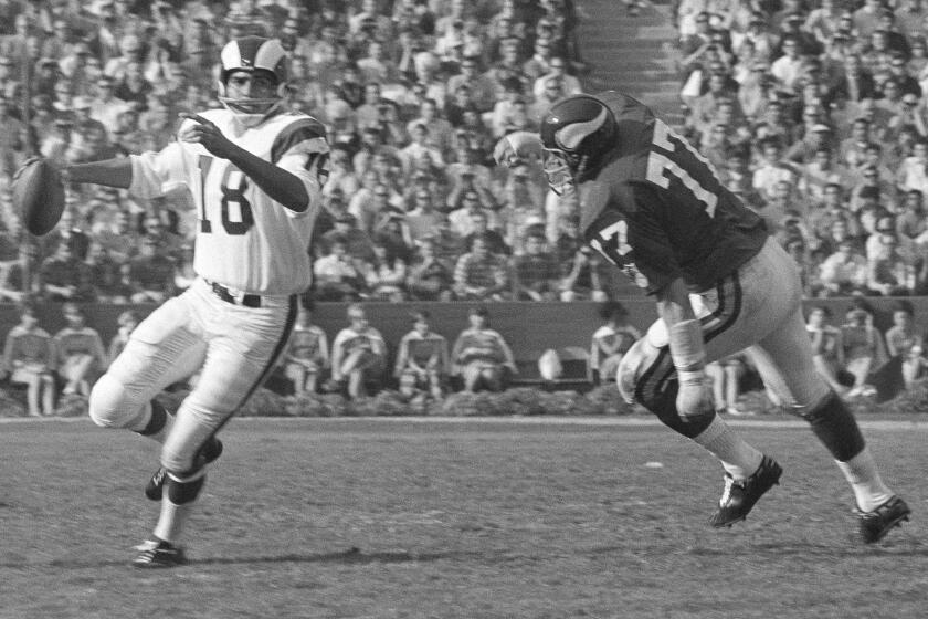 Los Angeles Rams quarterback Roman Gabriel fades back to pass as a Minnesota Viking defenseman closes in during their NFL game at the Coliseum in Los Angeles, Dec. 7, 1969. Gabriel was chosen Most Valuable Player in the NFL in a poll taken by The Associated Press of 48 writers and broadcasters in the 16 NFL cities. (AP Photo/Harry Harris)