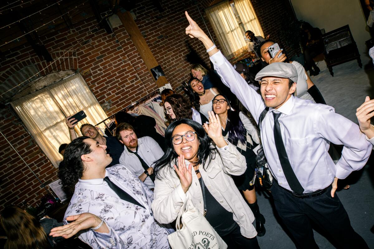 A photo of Taylor Swift fans dancing to her music at a listening party. 