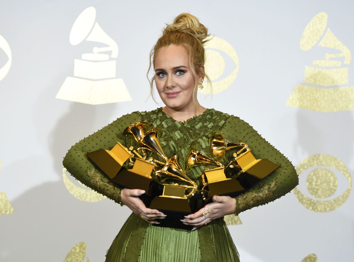 FILE - Adele poses in the press room with the awards for album of the year for "25", song of the year for "Hello", record of the year for "Hello", best pop solo performance for "Hello", and best pop vocal album for "25" at the Grammy Awards in Los Angeles on Feb. 12, 2017. Adele announced on Instagram that her “30” album will come out November 19. A new single, ‘Easy on Me,’ is being released on Friday.(Photo by Chris Pizzello/Invision/AP, File)