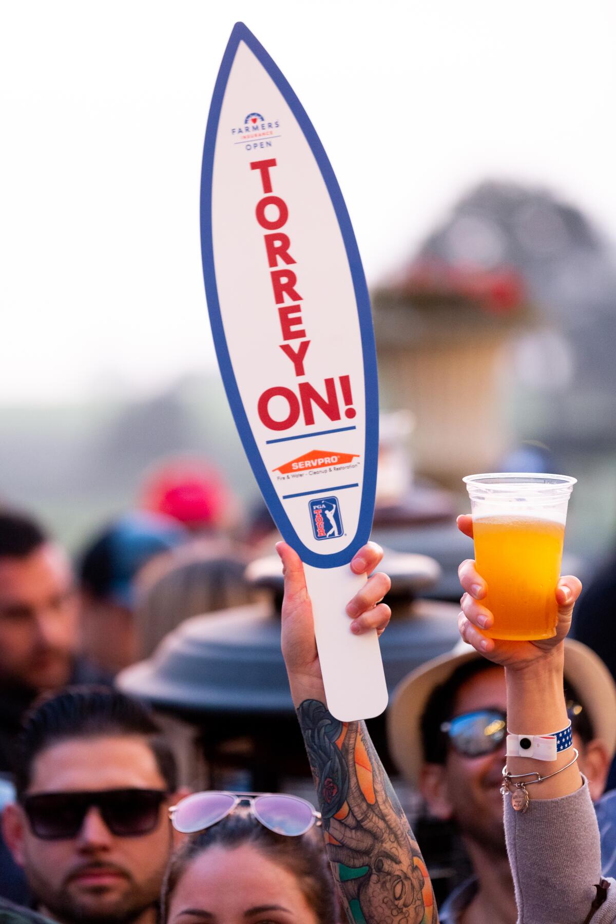 Golf fans holding up beer and signs 