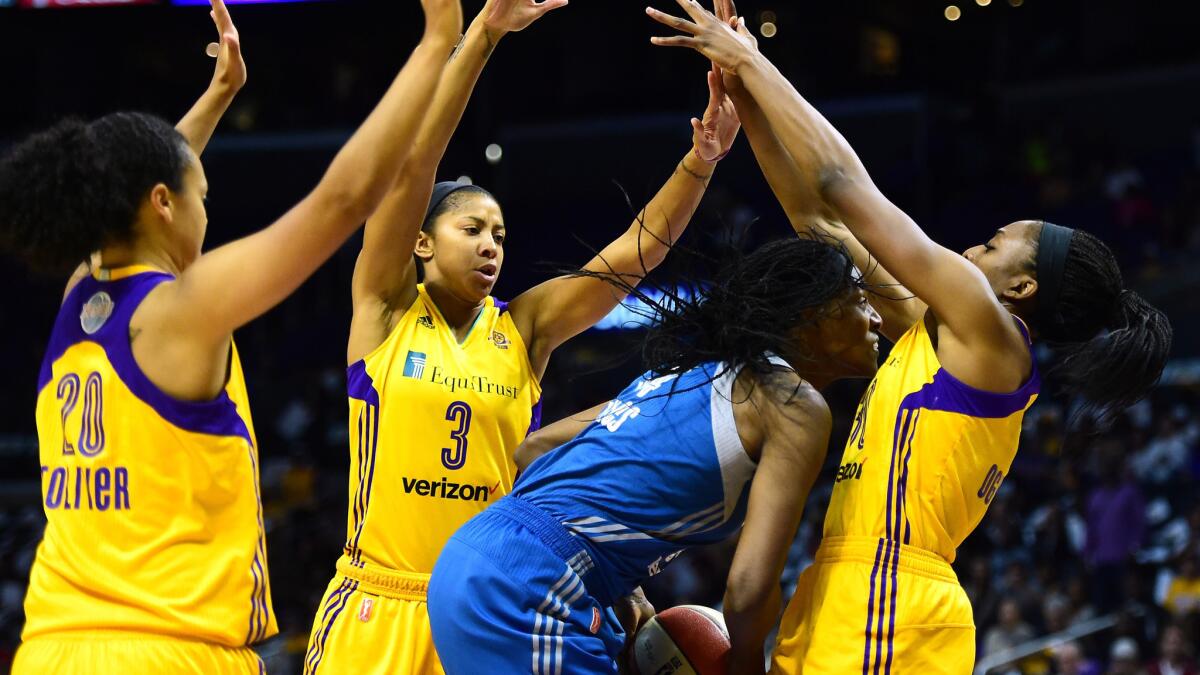The Sparks' Nneka Ogwumike, left, Candace Parker and Kristi Toliver surround Minnesota's Sylvia Fowles on Sunday.
