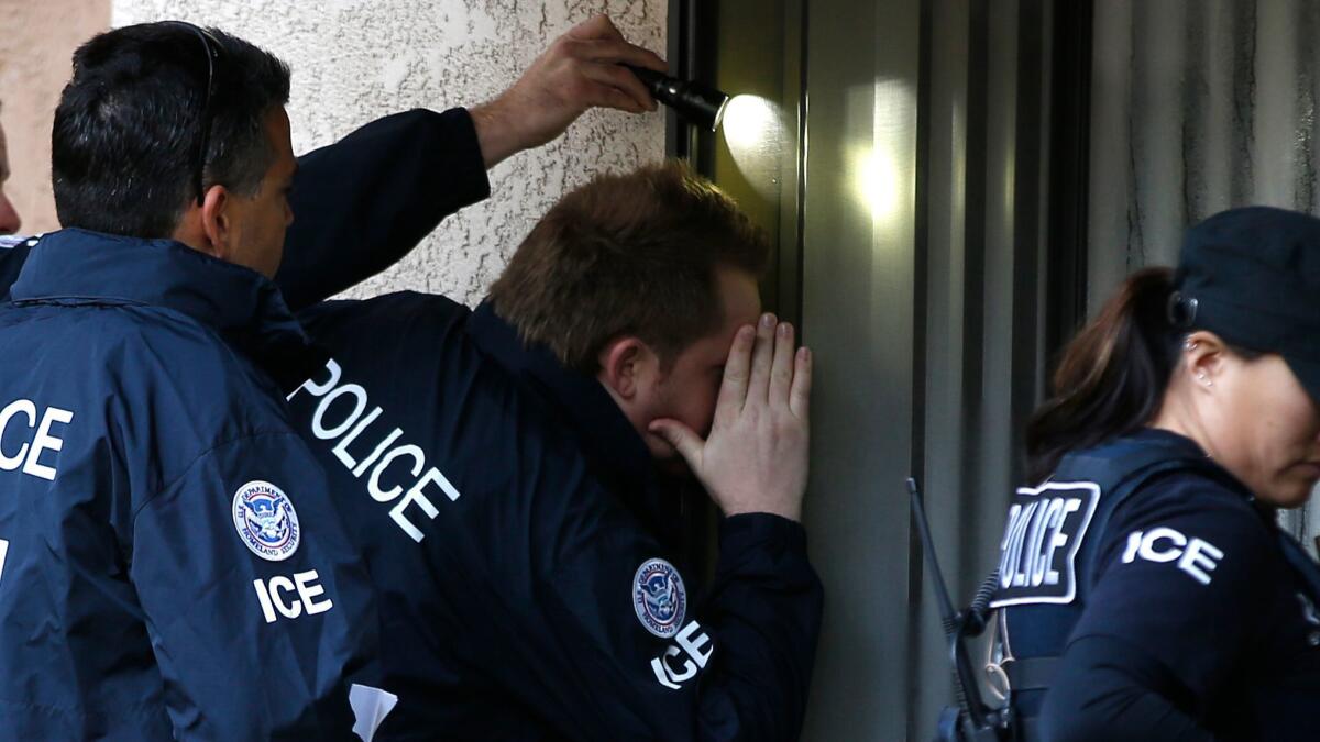 ICE Agents look into the window of an apartment in Rowland Heights while executing search warrants during the ongoing investigatiion into alleged birth tourism centers in March 2015.