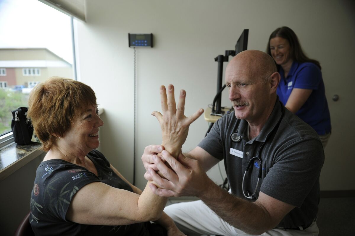 Kay Haneline consults with Dr. Bob Thomas about numbness in her arm and hand during a visit to the Alaska Medicare Clinic in Anchorage, Alaska.
