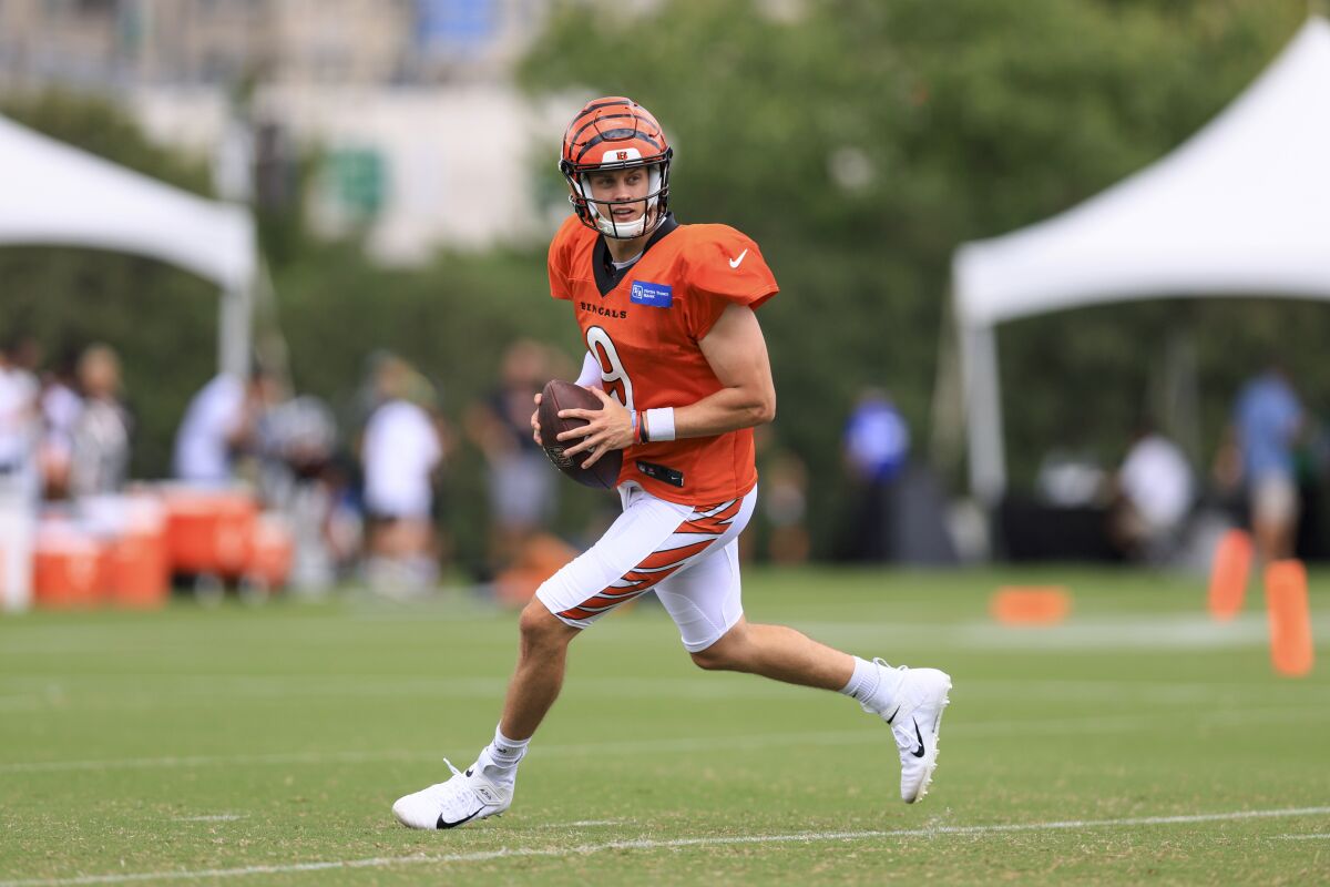 El quarterback de los Bengals de Cincinnati Joe Burrrow busca un receptor durante el entrenamiento, el lunes 15 de agosto de 2022, en Cincinnati. (AP Foto/Aaron Doster)