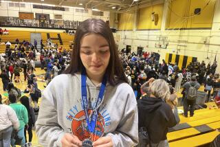 A teary eyed Melissa Guerrero-Brown, a junior at Banning, inspects a silver medal.