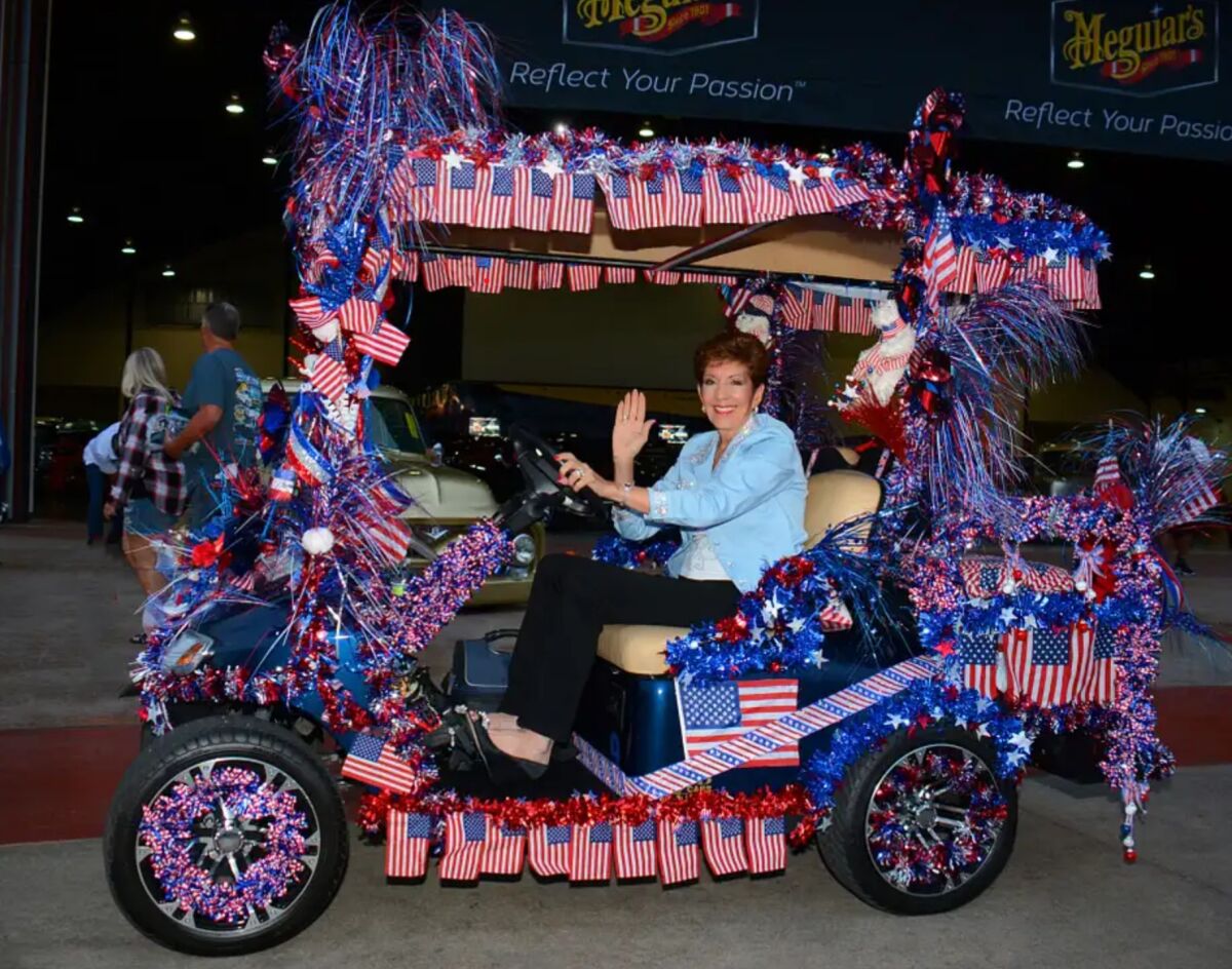 Lake Forest resident and Cruisin' for a Cure car show organizer Debbie Baker rides a golf cart at a recent event. 