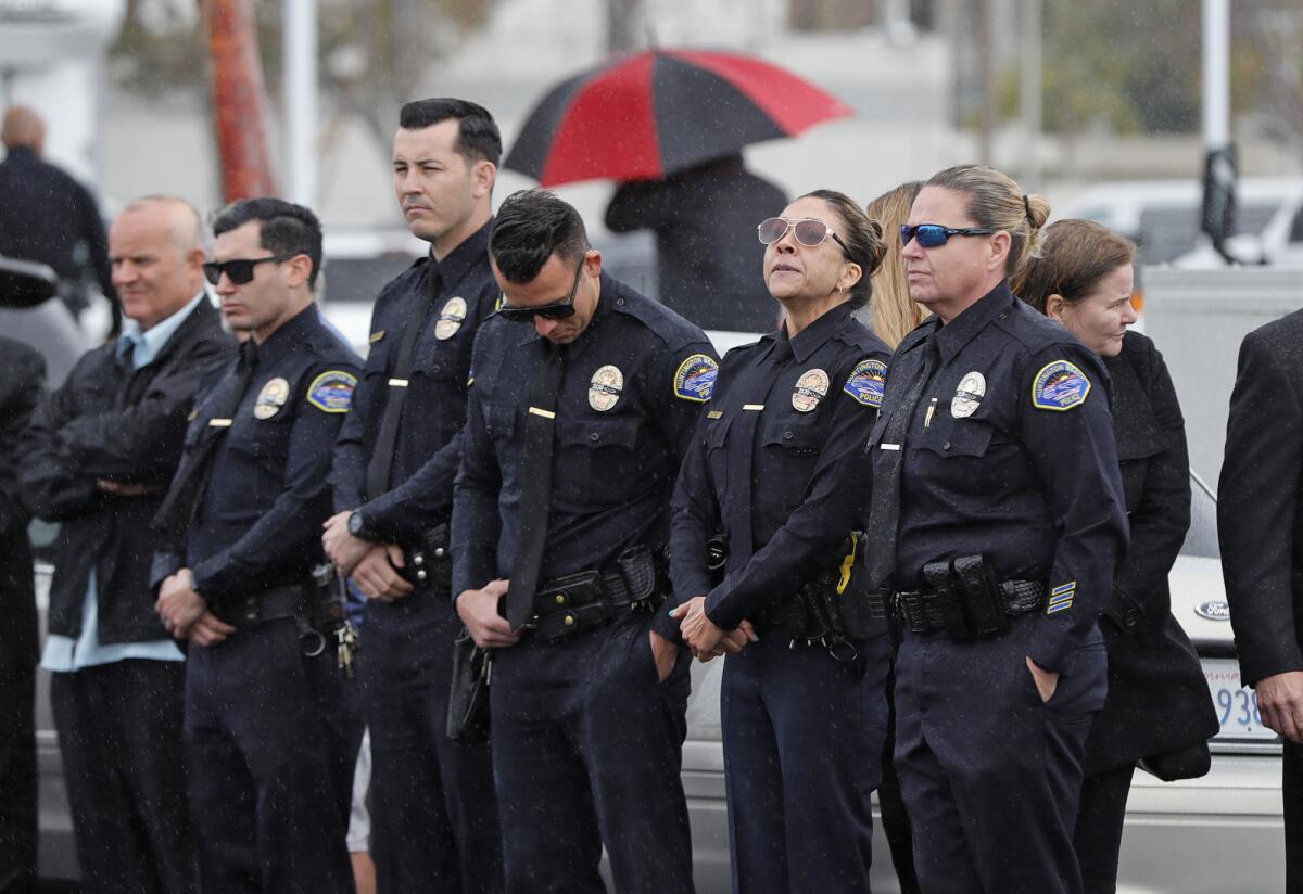 Members of the Huntington Beach Police Department stand at the beginning of the procession in honor of Nicholas Vella.