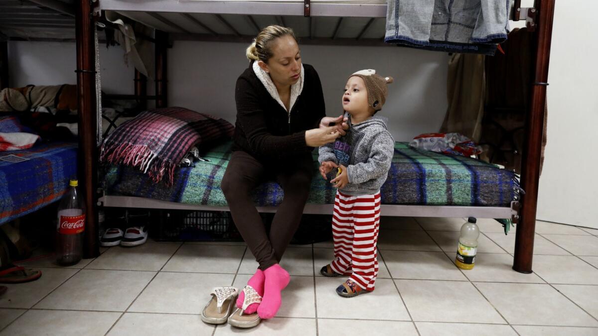 Evelyn Cepeda, 30, of Tegucigalpa, Honduras, with son Paul Cruz, 2, waits to present her case to U.S. immigration officials.