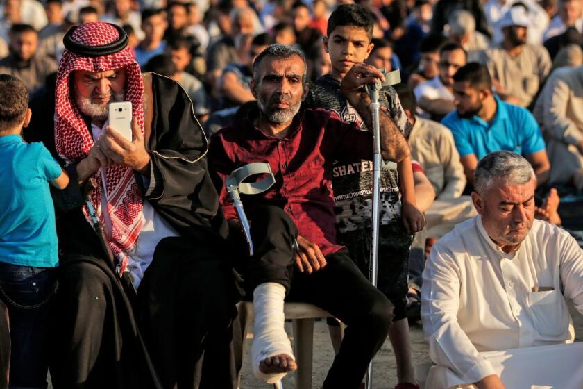 A Palestinian faithful injured during the "Great March of Return" attend morning prayers during the first day of the celebrations of Eid al-Fitr, at the Israel-Gaza border east of Gaza city on June 15, 2018. / AFP PHOTO / MAHMUD HAMSMAHMUD HAMS/AFP/Getty Images ** OUTS - ELSENT, FPG, CM - OUTS * NM, PH, VA if sourced by CT, LA or MoD **
