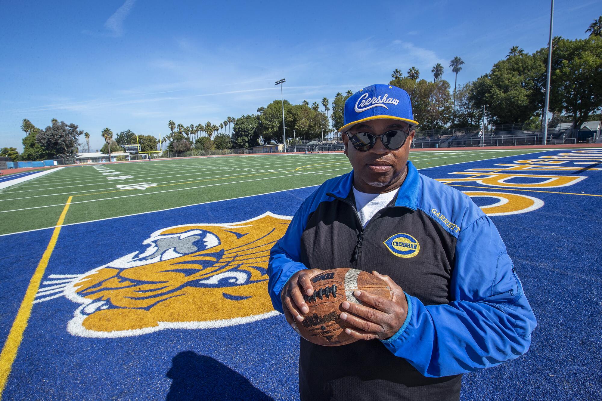 Crenshaw coach Robert Garrett in an end zone of the football field on campus.