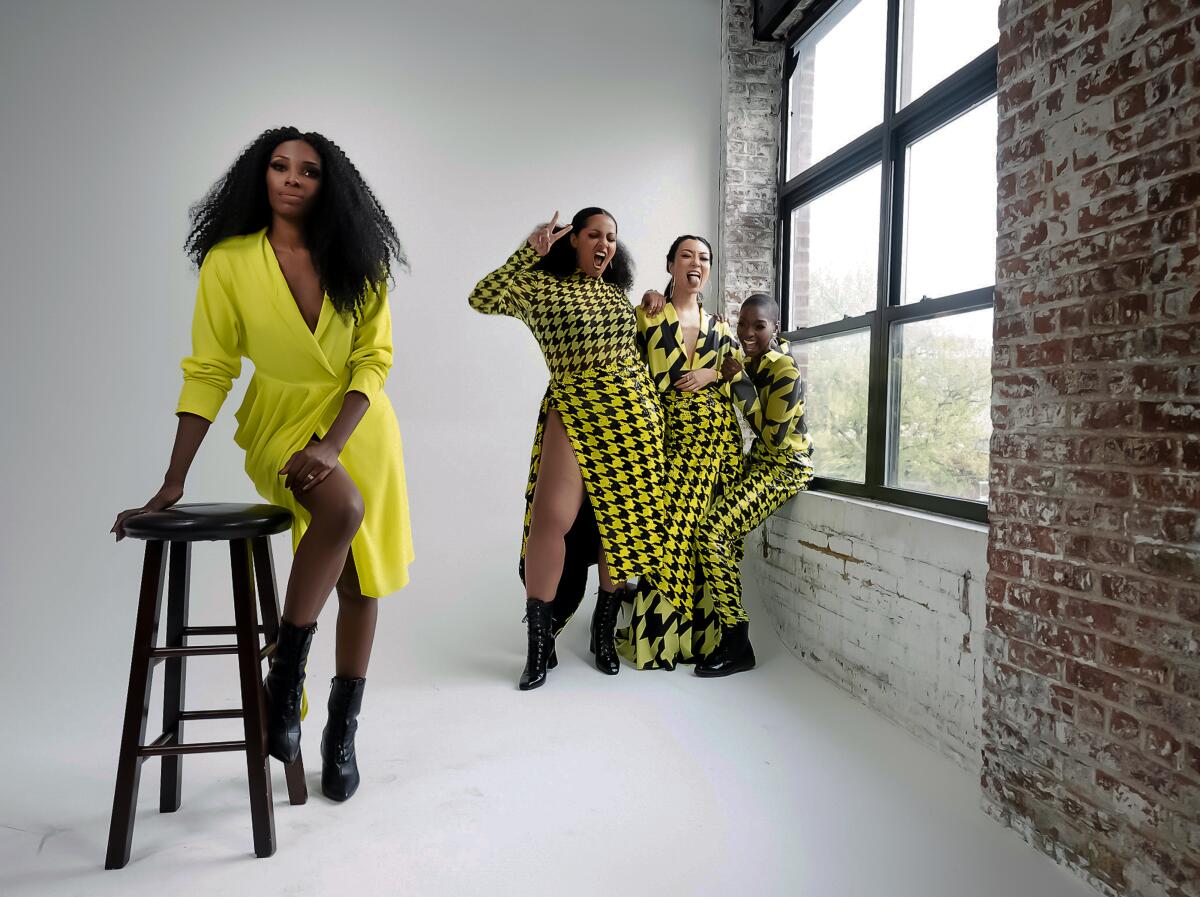 A fashion designer in yellow with three models in matching black-and-yellow houndstooth patterns.