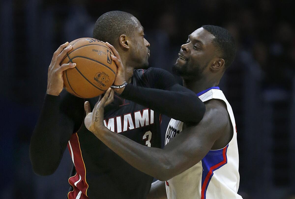 Lance Stephenson gets a hand on the ball while Heat guard Dwyane Wade tries to looks to pass during a game at Staples Center on Jan. 13.