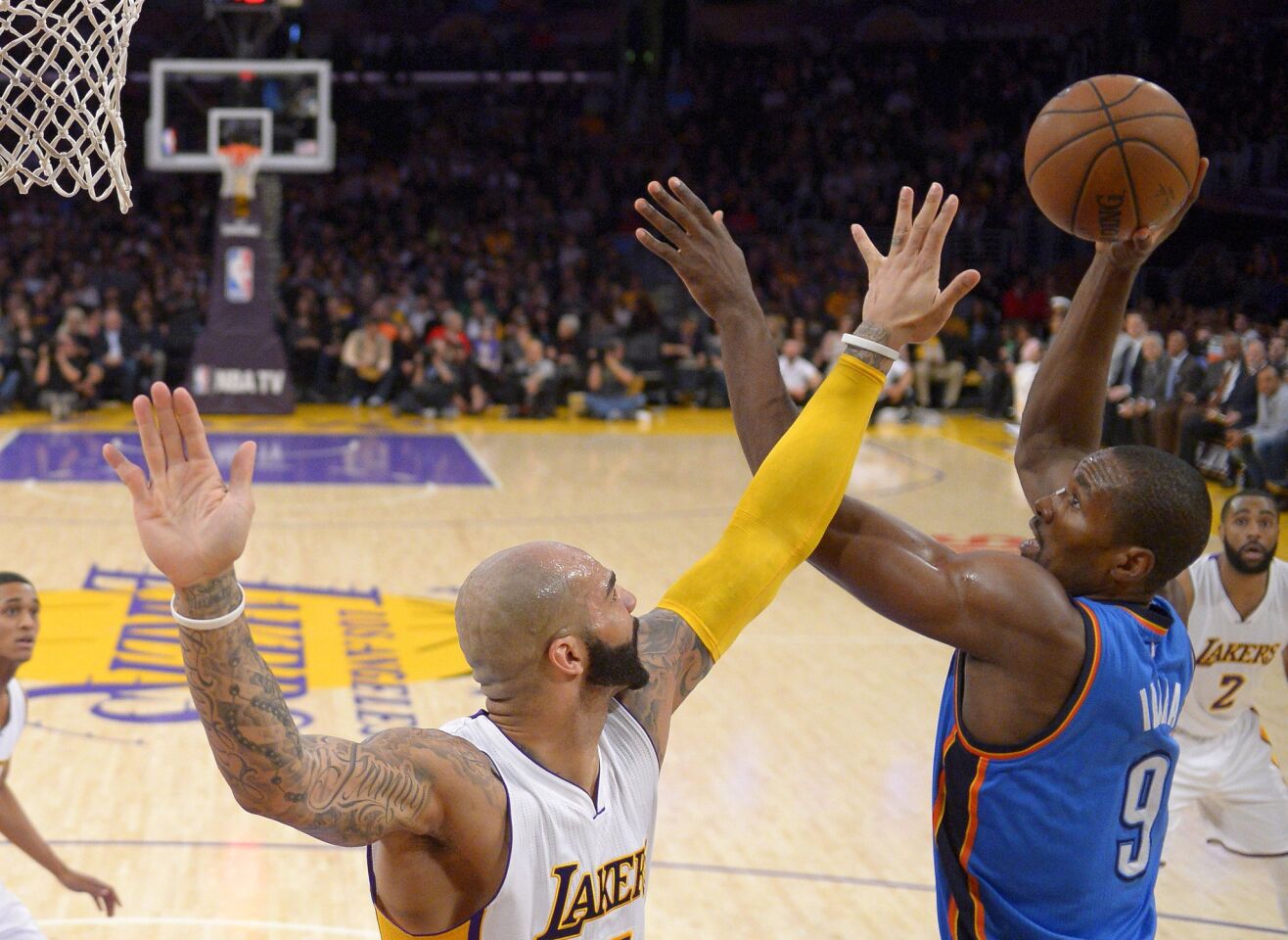 Thunder power forward Serge Ibaka goes up for a shot over the outstretched arm of Lakers power forward Carlos Boozer.