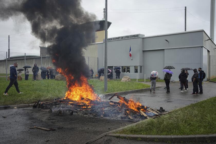 Prison workers gather during a protest outside the Corbas prison, outside Lyon, France, Wednesday, May 15, 2024 . A massive manhunt was underway in France on Wednesday for an armed gang that ambushed a prison convoy, killing two prison officers, seriously injuring three others and springing the inmate they were escorting. (AP Photo/Laurent Cirpiani)