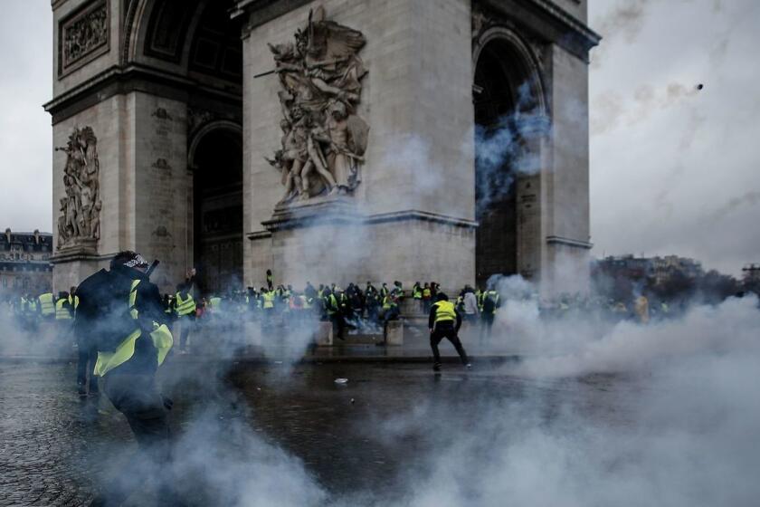 Manifestantes se enfrentan a la policía antidisturbios en el Arco de Triunfo de París la semana pasada durante una protesta contra el aumento de los precios del petróleo y los costos de vida.