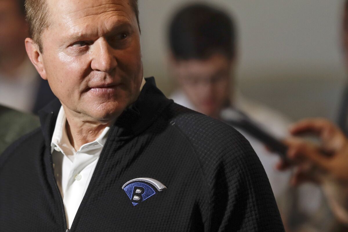 FILE - Sports agent Scott Boras, wearing a jacket with his personal logo, speaks at the Major League Baseball winter meetings in San Diego on Dec. 10, 2019. Boras, baseball’s most influential agent said the sport was the victim of a “competitive cancer” caused by teams unloading veterans to accumulate draft picks and said the Atlanta Braves’ World Series title was a direct result of tanking. (AP Photo/Gregory Bull, File)