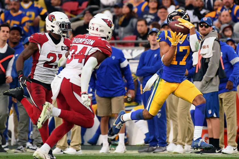 LOS ANGELES, CALIFORNIA DECEMBER 29, 2019-Rams reeiver Robert Woods catches a long pass in fornt of Cardinal defenders Patrick Peterson, left, and Jalen Thompson in the 4th quarter at the Coliseum Sunday. (Wally Skalij/Los Angerles Times)