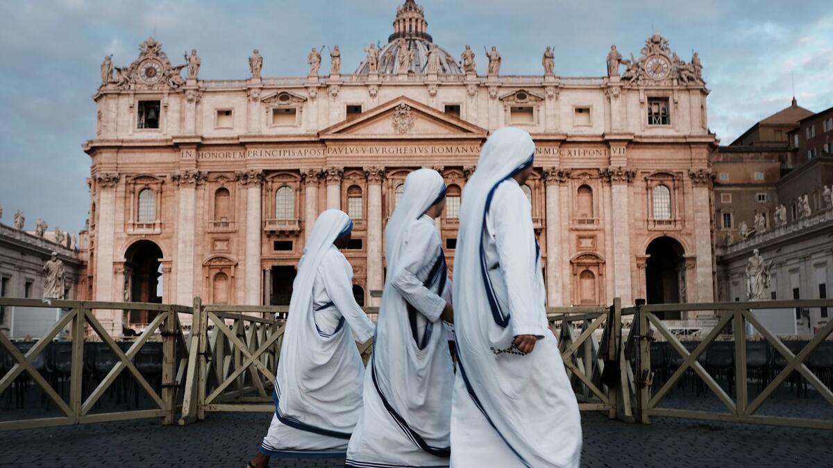 A group of nuns walk through St. Peter's Square at dawn on Monday in Vatican City. Tensions in the Vatican are high following accusations that Pope Francis covered up for an American ex-cardinal accused of sexual misconduct.