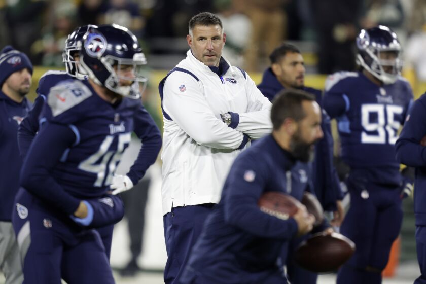 Tennessee Titans head coach Mike Vrabel, center, watches his team warm up before an NFL football game against the Green Bay Packers, Thursday, Nov. 17, 2022, in Green Bay, Wis. (AP Photo/Matt Ludtke)