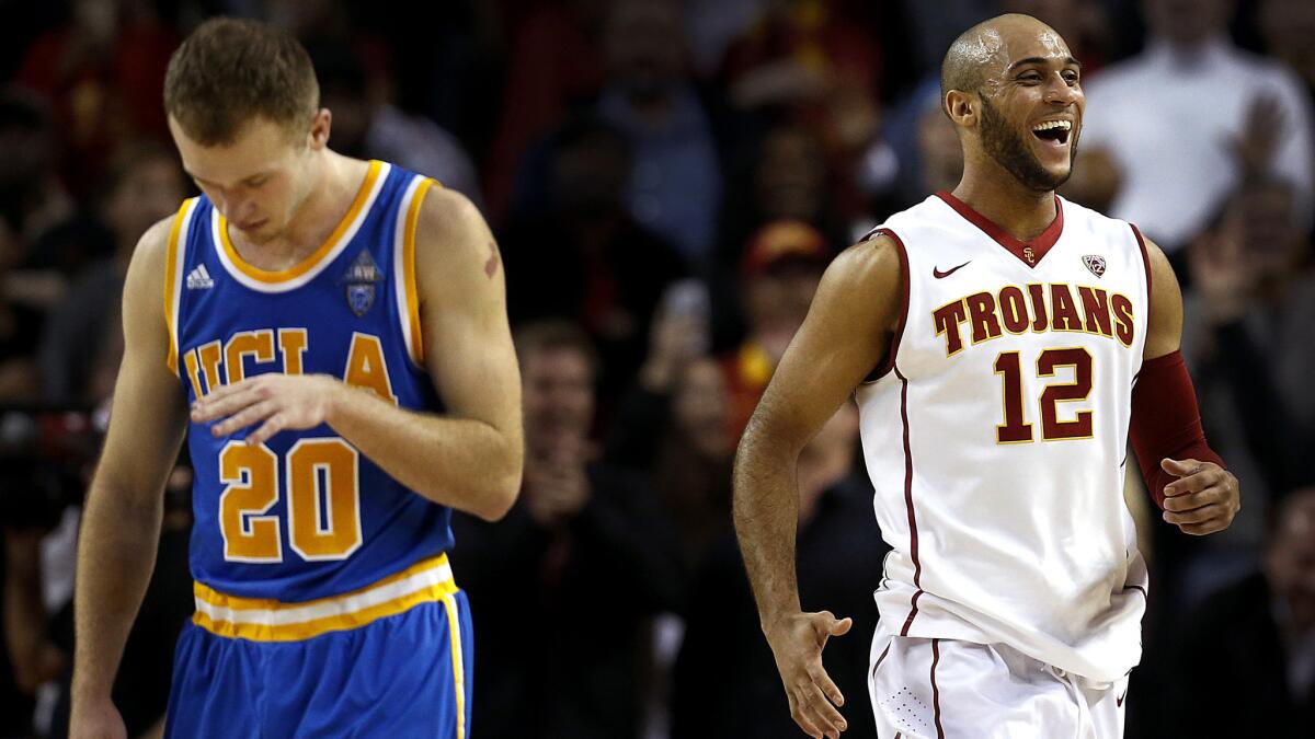 USC guard Julian Jacobs (12) celebrates the win over UCLA as Bruins guard Bryce Alford walks off the court.