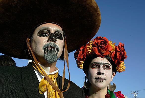 Daniel Hernandez, left, and his wife, Christina, have marched in the Day of the Dead procession for the last 13 years. The procession begins at Evergreen Cemetery and traditionally moves along Cesar Chavez Avenue, ending at a festival at the artists collective Self Help Graphics & Art.
