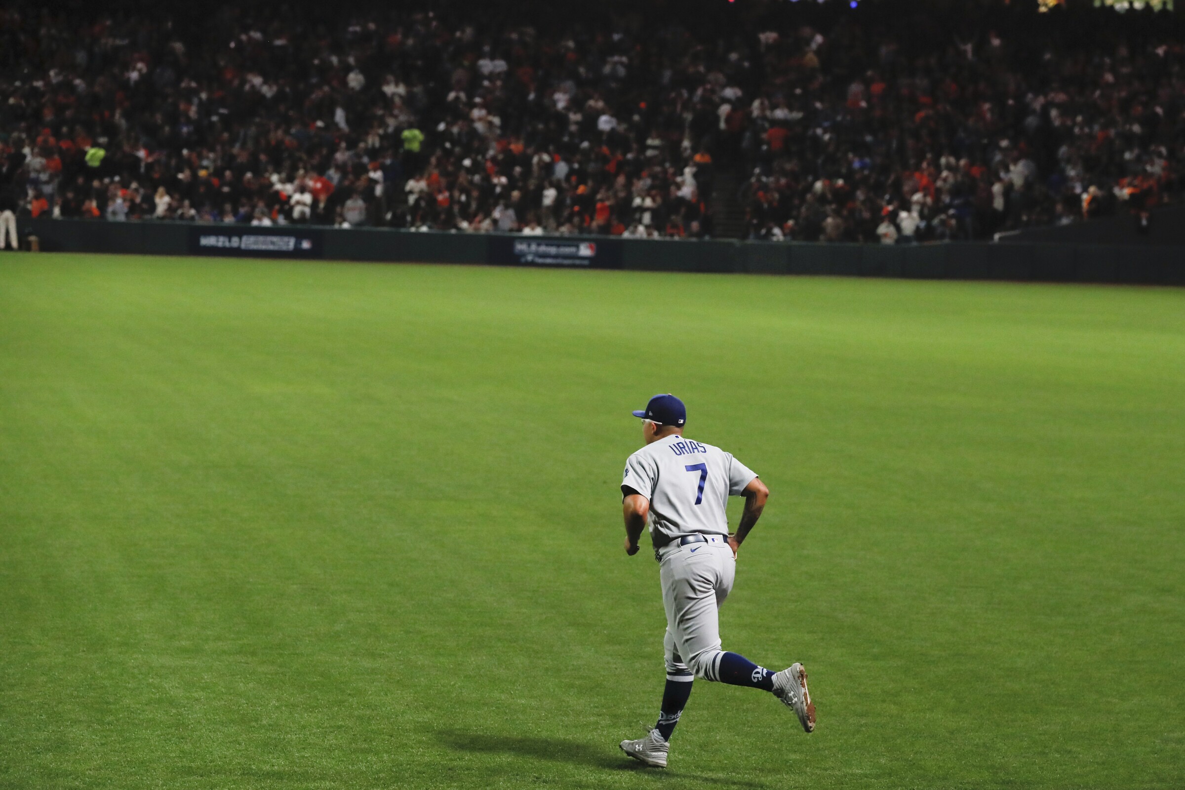 Dodgers pitcher Julio Urias is seen from behind as he runs onto the field from the bullpen