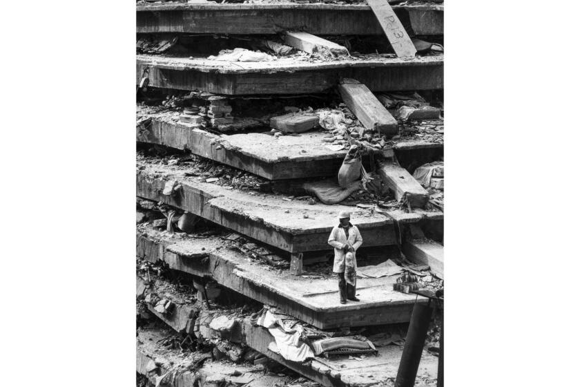 Sep. 19, 1985: Man stands on the wreckage of the General Hospital in Mexico City where collapsing floors killed 277 in earthquake.