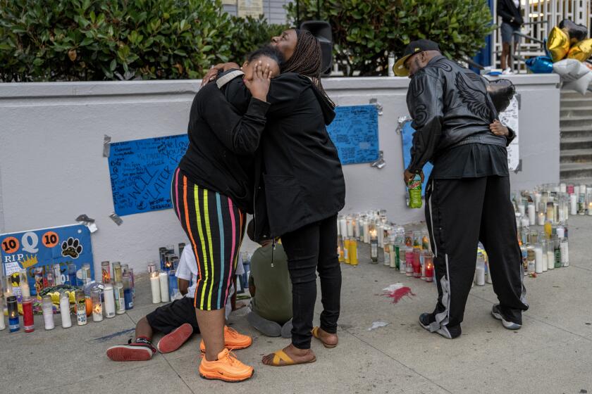 LOS ANGELES, CA - JUNE 12, 2023: The mother of slain 16-year-old basketball star Paradisha Cooperwood, left, is consoled by Laronia Wright at a memorial for Quincy Reese Jr. in front of Crenshaw High School on June 12, 2023 in Los Angeles, California. Reese was killed by a gunshot outside a party Saturday night.(Gina Ferazzi / Los Angeles Times)