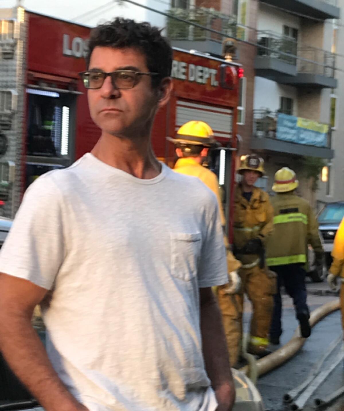 Arthur Aslanian stands outside an apartment complex he owns during a fire in 2022.