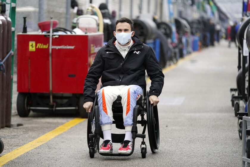 FILE - Robert Wickens makes his way to his pit stall during practice for the Rolex 24 hour auto race at Daytona International Speedway, Thursday, Jan. 27, 2022, in Daytona Beach, Fla. Wickens used hand controls last weekend to win his first race since a 2018 spinal cord injury temporarily ended his racing career. Across an ocean, former IndyCar driver Sam Schmidt and motorcycle racer Wayne Rainey also piloted vehicles during the annual Goodwood Festival of Speed in England. (AP Photo/John Raoux, File)