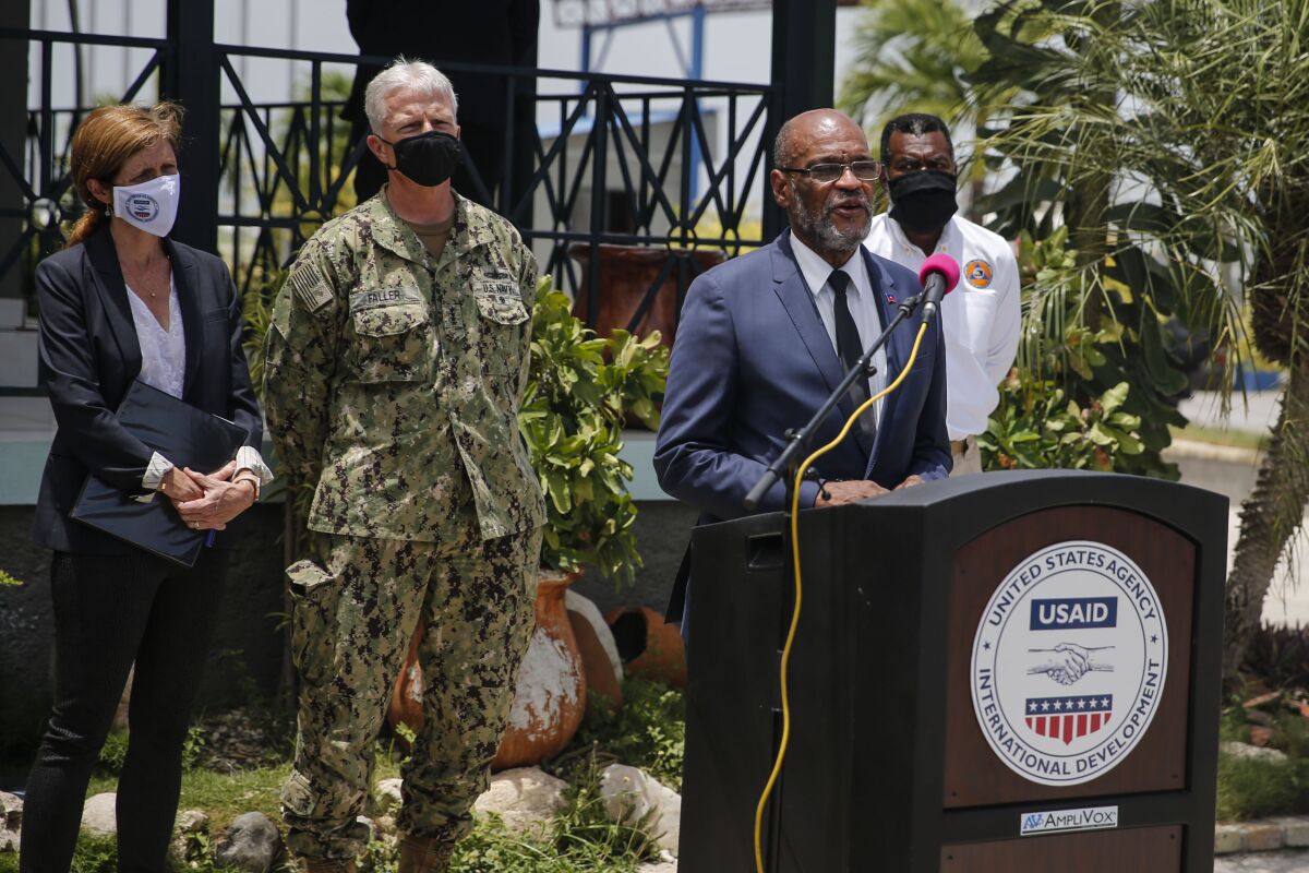 Haitian Prime Minister Ariel Henry speaks during a joint press conference with USAID and SOUTHCOM at the international airport in Port-au-Prince, Haiti,Thursday, Aug. 26, 2021, weeks after the 7.2 magnitude earthquake. At left are USAID Administrator Samantha Power and SOUTHCOM Commander Admiral Faller. (AP Photo/Joseph Odelyn)