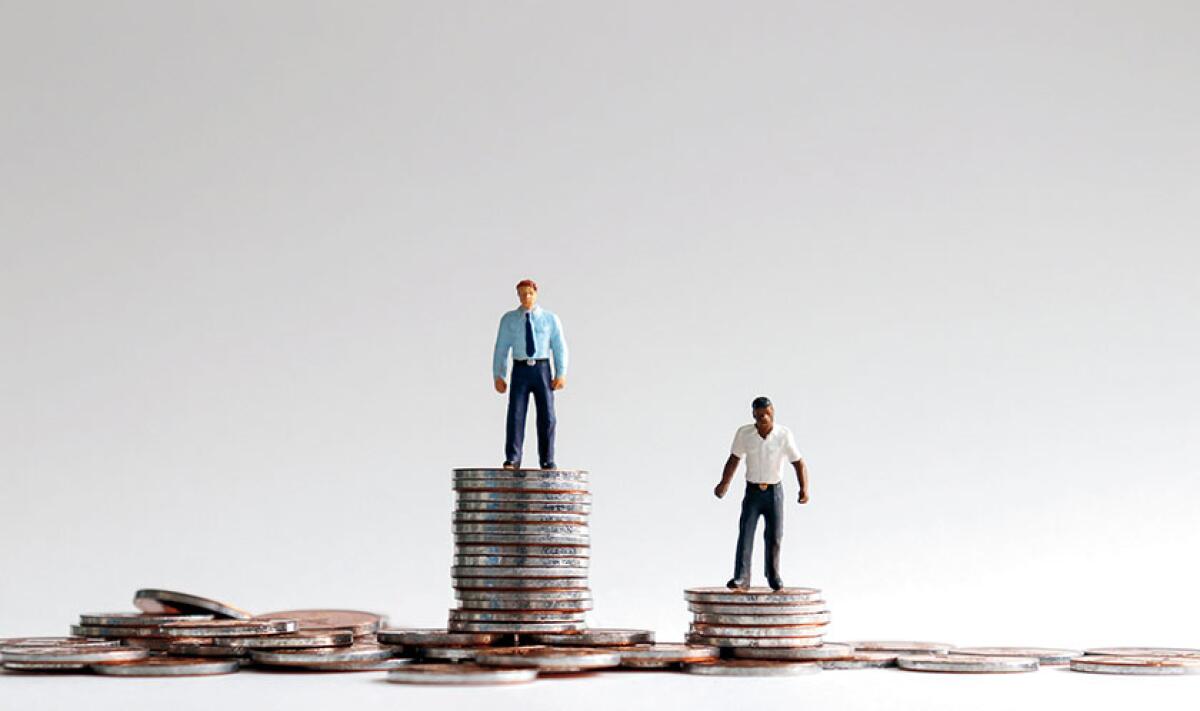 A photo illustration showing two small people standing on stacks of coins