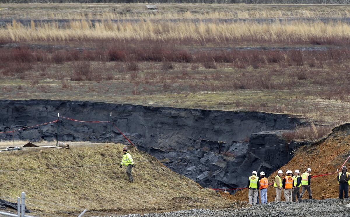 Duke Energy engineers and contractors survey the site of a coal ash spill at the Dan River Power Plant in Eden, N.C.